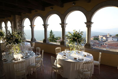 Chairs and tables in restaurant by building