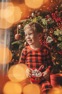 Portrait of smiling girl playing with christmas tree