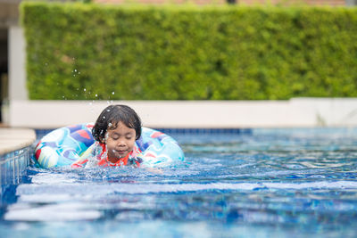 Little adorable girl have fun at outdoor swimming pool