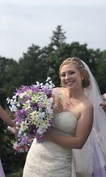 Close-up of smiling woman standing against white flowering plants