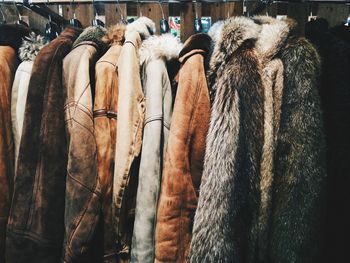 Close-up side view of jackets on rack