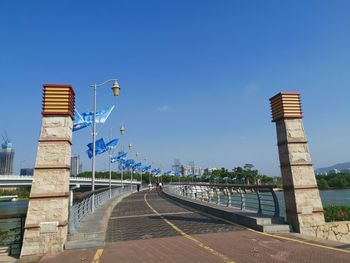 Road by building against clear blue sky
