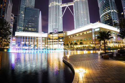 Reflection of illuminated buildings in city at night