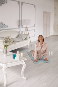 Woman sitting on table at home