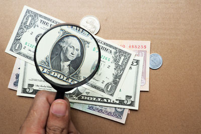 Close-up of hand holding eyeglasses against white background