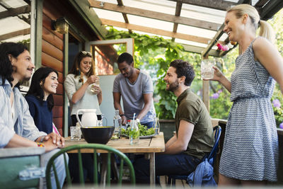 Happy multi-ethnic friends enjoying party at log cabin