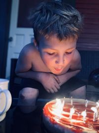 Boy blowing candles at home