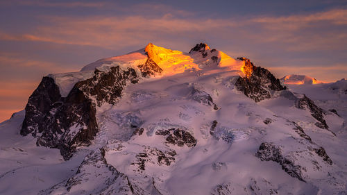 Scenic view of snowcapped mountains against sky during sunset