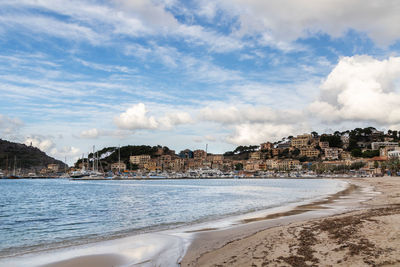 Panoramic view of town by sea against sky