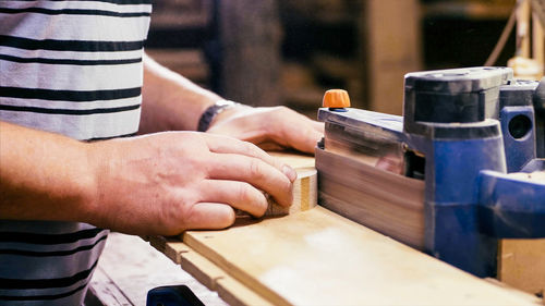 Midsection of man working on wood