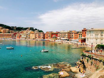 View of buildings at waterfront against cloudy sky