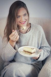 Portrait of woman eating food at home