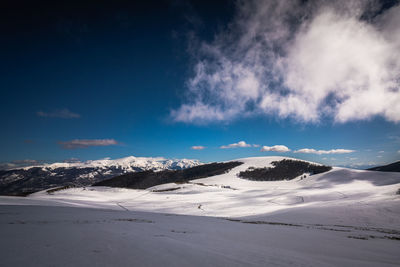 Scenic view of snow covered mountains against sky