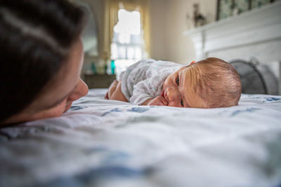 Rear view of people relaxing on bed