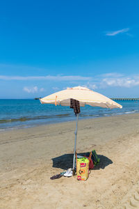 Lifeguard hut on beach against blue sky