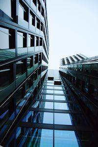 Low angle view of modern glass building against sky