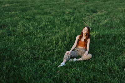 Full length of woman doing yoga on grassy field