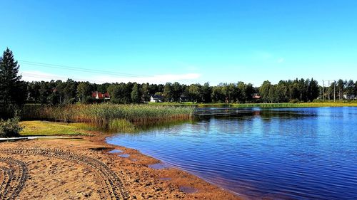 Scenic view of lake against clear blue sky