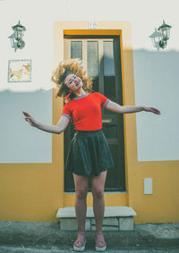 Full length of woman standing against wall