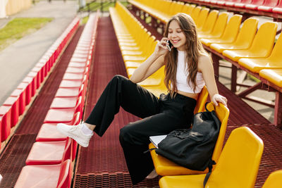 Portrait of young woman sitting in city