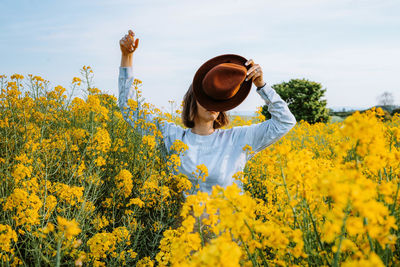 Woman with yellow flowers in field