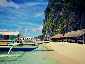 Boats moored on beach against sky