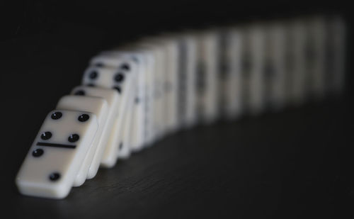 Close-up of guitar on table against black background