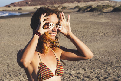 Portrait of man wearing sunglasses standing on beach