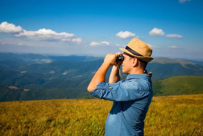 Man photographing against sky