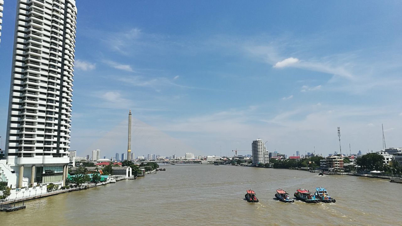 building exterior, architecture, built structure, city, water, sky, nautical vessel, transportation, waterfront, skyscraper, river, office building, modern, city life, urban skyline, development, tall - high, cloud - sky, day, outdoors, harbor, financial district, canal, building story