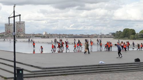 Group of people by the sea against sky