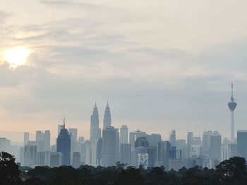 Buildings in city against cloudy sky