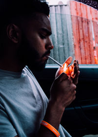 Man lighting cigarette in car