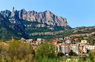 Scenic view of town against montserrat mountains against clear sky