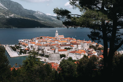 High angle view of townscape by sea against sky