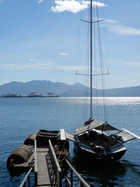 Sailboats moored on sea against sky