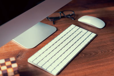 High angle view of keyboard and mouse by desktop pc on desk