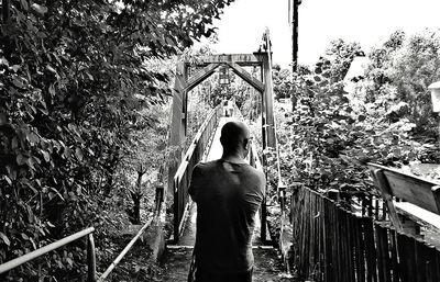 Rear view of woman standing against trees