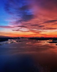 Scenic view of sea against dramatic sky during sunset