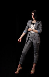 Young woman wearing hat against black background