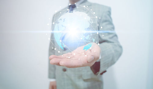 Digital composite image of hand holding mobile phone