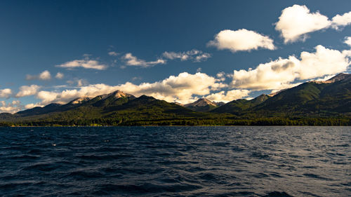 Scenic view of lake by mountains against sky