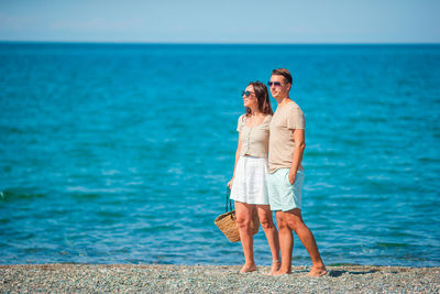 Full length of couple standing at sea shore