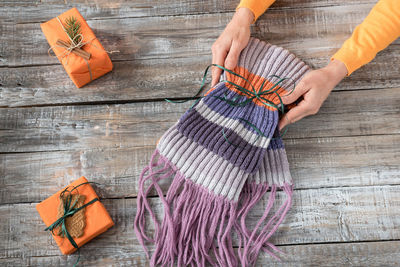 Cropped image of woman holding scarf on table