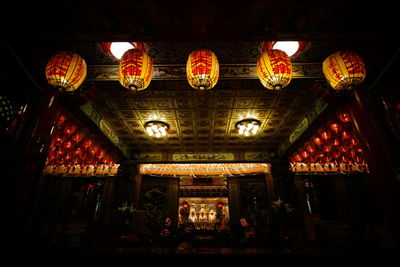 Low angle view of illuminated lanterns hanging at night