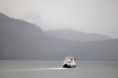 Boat in sea with mountain in background