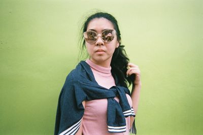 Portrait of young woman standing against white background