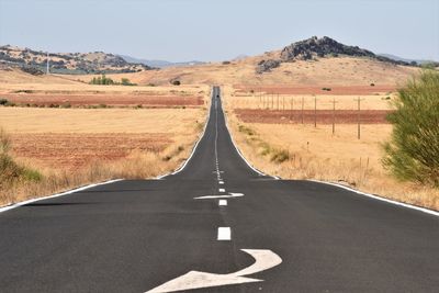 Road amidst field against sky