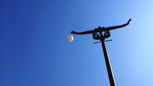 Low angle view of street light against clear blue sky