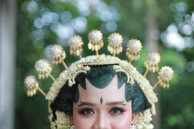 Close-up portrait of young woman with flower in a head